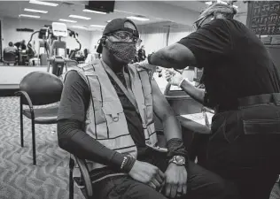  ?? Brett Coomer / Staff file photo ?? United Airlines employee Adam Chase receives a Pfizer vaccine in April during a vaccine clinic at George Bush Interconti­nental Airport. United said 97 percent of its workers have been vaccinated.