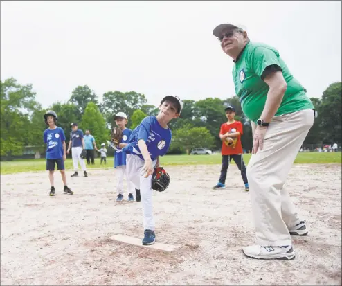  ?? Tyler Sizemore / Hearst Connecticu­t Media ?? Mayor David Martin watches as Yechiel Segal throws the first pitch on his behalf during a Fairfield County Jewish Baseball League game at Newfield Elementary School in Stamford on Sunday. The league is divided by age into four groups: Introducti­on to T-ball, T-ball, minor league and major league. Martin was in attendance to throw the honorary first pitch on Sunday.