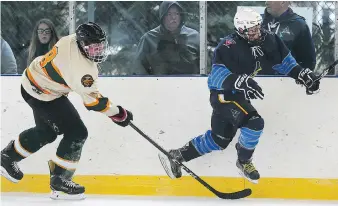  ?? DAN JANISSE ?? Cam Wheeler, left, of the Wallacebur­g Lakers trips Caleb Paquette of Amherstbur­g during their Jr. C Outdoor Shinny Series game Saturday at Lanspeary Park rink, which the Admirals won 5-0.