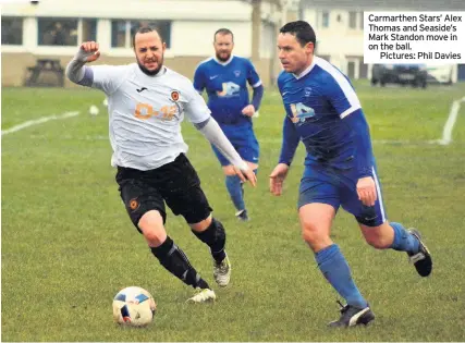  ??  ?? Carmarthen Stars’ Alex Thomas and Seaside’s Mark Standon move in on the ball.Pictures: Phil Davies