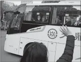  ?? NG HAN GUAN AP PHOTO ?? Workers wave to the team of experts from the World Health Organizati­on who left their quarantine hotel in a bus in Wuhan in central China’s Hubei province on Thursday,