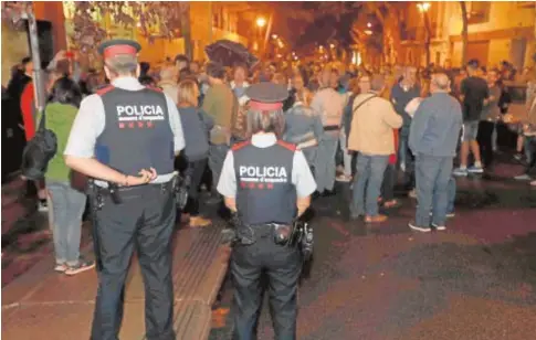  ?? EFE ?? Dos mossos observan el 1-O los movimiento­s alrededor de un colegio electoral de Barcelona sin intervenir