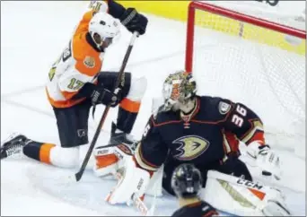  ?? TOM MIHALEK — THE ASSOCIATED PRESS ?? Wayne Simmonds, left, scores past Ducks goalie John Gibson during the second period Thursday. It was the Flyers’ lone goal in seven power plays on the night as they fell to Anaheim, 3-2.