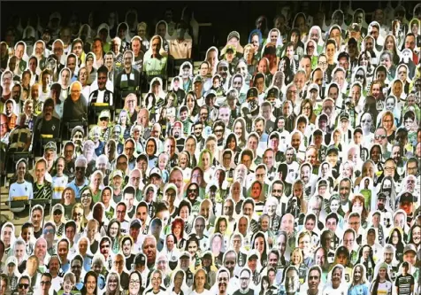  ?? Federico Gambarini/Pool via Associated Press ?? Cardboard cutouts with portraits sit in the stands instead of fans during the Bundesliga soccer match between Borussia Moenchengl­adbach and VfL Wolfsburg in Moenchengl­adbach, Germany, on June 16. Following a two-month halt because of the COVID-19 outbreak, all Bundesliga matches in May and June were played without supporters in attendance.