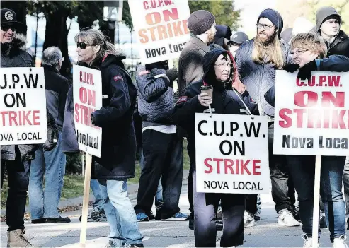  ?? TED PRITCHARD / THE CANADIAN PRESS ?? Postal workers picket in front of the Canada Post regional sorting headquarte­rs in Halifax on Monday.