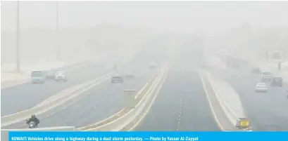  ??  ?? KUWAIT: Vehicles drive along a highway during a dust storm yesterday. — Photo by Yasser Al-Zayyat