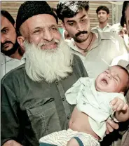  ?? REUTERS ?? Renowned social worker Abdul Sattar Edhi holds a child handed over to him by local police in Karachi on 15 March 2002.