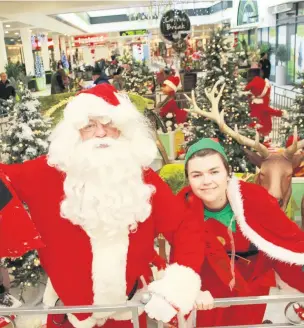  ??  ?? ●●Santa and his elf at Rochdale Exchange Shopping Centre last year