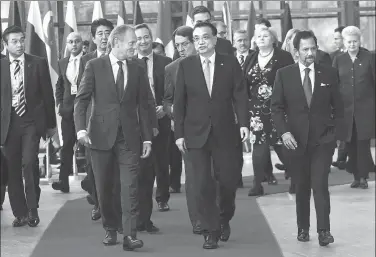  ?? EMMANUEL DUNAND / AFP ?? Premier Li Keqiang and European Council President Donald Tusk speak as they walk with Sultan of Brunei Haji Hassanal Bolkiah (right) and other leaders arriving to pose for a group photograph during an ASEM summit at the European Council in Brussels on Friday.