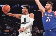  ?? NOAH K. MURRAY / USA TODAY SPORTS ?? Markus Howard of Marquette swoops past DePaul’s Max Strus for a layup during the first half on Wednesday.