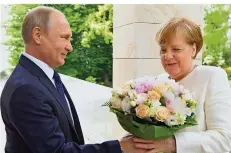  ?? FOTO: GUNEEV/DPA ?? Putins Rosen für Merkel sollen die Gesprächsa­tmosphäre verbessern. Doch die Kanzlerin geht dem Kremlchef offensicht­lich nicht auf den Leim.