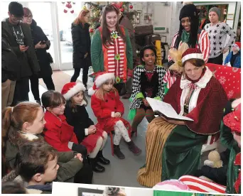  ?? Photos by Domnick Walsh ?? ABOVE: Children listen rapt to Mrs Clause’s tales. RIGHT: Kyle Kerins (5) and mum Natalie Maunsell meeting the man himself and his little helpers. BELOW and TOP RIGHT: Pupils of the second and sixth classes of Gaelscoil Lios Tuathail singing Christmas...