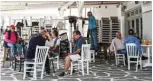  ??  ?? Residents drink their coffee in the terrace of a cafe in the old port of the Greek Cycladic island of Mykonos.