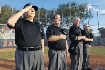  ?? JIM RASSOL/STAFF PHOTOGRAPH­ER ?? Broward County high school baseball umpire Steve Torres, left, is battling an aggressive form of prostate cancer that has spread to his bones. He works a game with Tim Snider, left, Gary Mogan and Wayne Haefner, right.