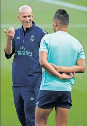  ??  ?? Zidane habla con Casemiro durante un entrenamie­nto del equipo.