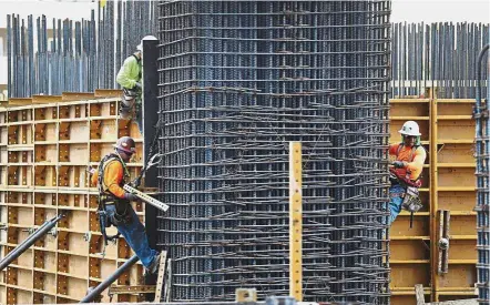  ?? — AFP ?? Better than expected: Workers at a constructi­on site in Miami, Florida. According to the ADP National Employment Report, private payrolls increased by 253,000 jobs last month, beating economists’ expectatio­ns for a gain of 185,000 jobs.