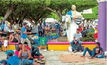  ??  ?? A LA ESPERA. UN GRUPO DE MIGRANTES DESCANSA EN EL PARQUE CENTRAL EN CIUDAD HIDALGO, MÉXICO, EL SÁBADO.