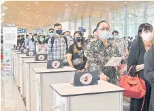  ?? — Bernama photo ?? Passengers on flight Singapore Airlines SQ108 from Singapore are seen queuing up during arrival at Kuala Lumpur Internatio­nal Airport via the VTL.