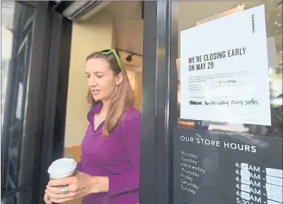  ?? FREDERIC J. BROWN — GETTY IMAGES ?? A Starbucks customer steps out of a store with her purchase in Los Angeles beside a sign posted notifying customers of its closure.