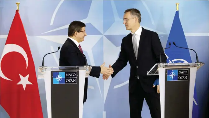  ?? — AFP ?? BRUSSELS: Turkish Prime Minister Ahmet Davutoglu (left) shakes hands with NATO Secretary General Jens Stoltenber­g after addressing a media conference at the NATO headquarte­rs yesterday.