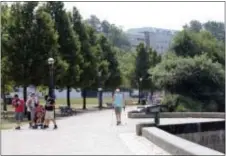  ?? RACHEL LA CORTE — THE ASSOCIATED PRESS ?? Dave Thysell, right, walks around Capitol Lake in Olympia, Wash., on Wednesday as temperatur­es were expected to climb to near 100 degrees.