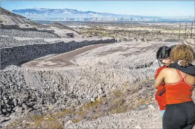  ?? L.E. Baskow Las Vegas Review-journal @Left_eye_images ?? Miriam Hejji, left, and friend Nictoria Pleasant-rede embrace along the Amargosa Trail, where Miriam’s 26-year-old sister, Jawaher Hejji, was reported missing Dec. 23. The top photo shows a missing person flyer for Jawaher Hejji posted along the trail in Henderson.