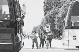  ?? PATRICK SEMANSKY/AP ?? Grant Curry, left, of Indianapol­is, and his son Gavin take part in a rally May 13 to raise awareness of bus operators.