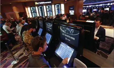  ?? ASSOCIATED PRESS FILE PHOTO ?? In this March 11, 2020, file photo, patrons place in person bets during the launch of legalized sports betting in Michigan at the MGM Grand Detroit casino in Detroit. Online sports betting and online gambling launched in January before the biggest profession­al football event of the year – the Super Bowl. Since then, online wagering is promising to be a tax windfall for Michigan from the hefty taxes charged to online casinos that offer gaming platforms.