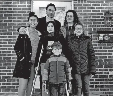  ?? ERIN HOOLEY/CHICAGO TRIBUNE ?? Fatih Yildirim and his wife Amy, top, with their children, Destiny, 19, from left, Yasemin, 12, Meryem, 11, and Ihsan, 5, stand outside their home Wednesday in Schaumburg. The family is excited to usher in a new era with President Joe Biden.