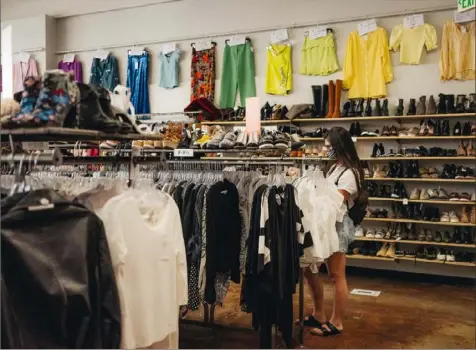  ?? Rozette Rago/The New York Times ?? A shopper wears a face mask while browsing the clothing racks at Crossroads Trading, a consignmen­t store with used and new clothing, in Studio City, Calif.