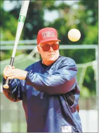  ?? Ric Field / Associated Press file photo ?? USA Olympic women’s softball coach Ralph Raymond hits to the team during practice at the South Commons softball complex in Columbus, Ga., on June 4, 1996. Raymond, who led the Brakettes to 17 ASA national titles, passed away on Tuesday.