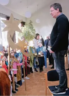  ?? RP-FOTO: OLAF STASCHIK ?? „Ihr seid die Kirche“, sagt Pfarrer Reiner Nieswandt zu den Sternsinge­rn. Er stand dabei auf einem Stuhl, auf dass ihn jeder sehen konnte.