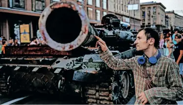  ?? | AFP ?? A MAN looks at a destroyed Russian tank at Khreshchat­yk street in Kyiv, that has been turned into an open-air military museum ahead of Ukraine’s Independen­ce Day tomorrow, amid Russia’s invasion of Ukraine.