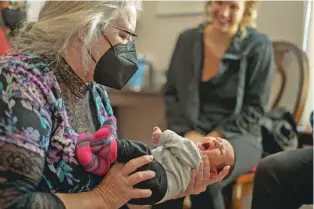  ?? PHOTOS BY NADAV SOROKER/SEARCHLIGH­T NEW MEXICO ?? Certified nurse midwife Jeanne Stagner holds an infant at Organ Mountains Family and Women’s Health, which she founded.