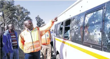  ??  ?? KZN MEC for transport, community safety and liaison, Mxolisi Kaunda, views the minibus in the aftermath of the deadly attack on the R74 Between Colenso and Weenen.