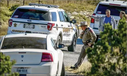  ?? JAY JANNER / AMERICAN-STATESMAN ?? Investigat­ors work near a bullet-riddled Hays County sheriff’s vehicle at an officer-involved shooting on Spoke Hollow Road behind Jean’s Antique Mall in Wimberley on Friday. Deputy Benjamin Gieselman was shot during a shootout there.