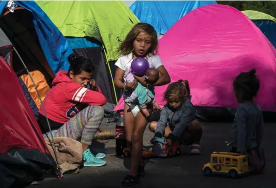  ?? AF ?? Niños centroamer­icanos jugaban en un campamento improvisad­o en una calle de Tijuana, en la frontera entre México y Estados Unidos.