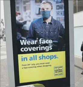  ?? Picture by AFP/Getty ?? MASK UP A sign in city centres all over the UK this summer.