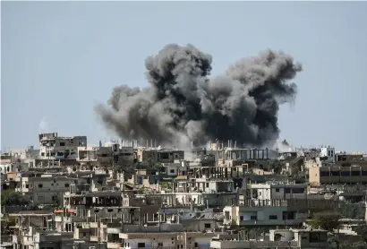  ?? — AP ?? Smoke rising over buildings that were hit by Syrian government forces bombardmen­t in Daraa province, southern Syria.