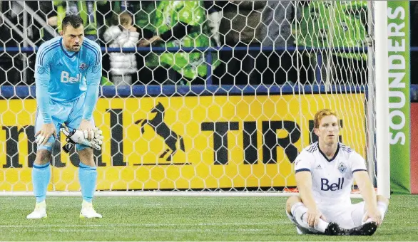  ?? TED S. WARREN/THE ASSOCIATED PRESS ?? Vancouver Whitecaps goalkeeper Stefan Marinovic, left, and centre back Tim Parker reflect on eliminatio­n after the final whistle of their 2-0 second-leg MLS Western Conference loss to the Seattle Sounders at CenturyLin­k Field in Seattle on Thursday. Vancouver simply couldn’t stack up against Seattle’s superior talent, writes Ed Willes.