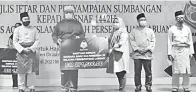  ??  ?? SIMBOLIK: Penyerahan simbolik kepada wakil penerima bantuan saudara baharu daripada MAIWP.