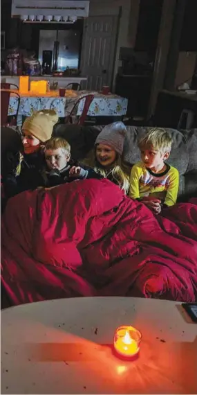  ??  ?? A family huddles around as they try to stay warm in their home in the BlackHawk neighbourh­ood in Pflugervil­le, Texas.