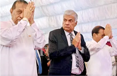  ?? ?? TAKING THE FIFTH PRECEPT: Prime Minister Ranil and Speaker Karu swear not to take any intoxicant hereafter according to Maithri’s New Testament revealed at Independen­ce Square this Wednesday