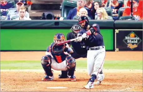  ??  ?? Kurt Suzuki of the Washington Nationals hits a solo home run against the Houston Astros during the seventh inning in game two of the 2019 World Series at Minute Maid Park on Wednesday in Houston, Texas.