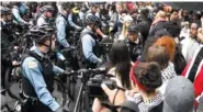  ?? AP PHOTO/MATT MARTON ?? Protesters stand near police in the downtown area Friday after a jury convicted white Chicago police officer Jason Van Dyke of second-degree murder in the 2014 shooting of black teenager Laquan McDonald in Chicago.