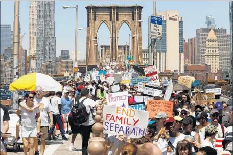  ?? Carolyn Cole Los Angeles Times ?? THOUSANDS of protesters clog the Brooklyn Bridge in New York, calling for the reunificat­ion of families split by U.S. immigratio­n policy.