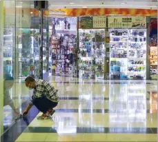  ?? CALVIN NG / CHINA DAILY ?? Disappoint­ed at the lack of business, a shop owner closes his store early at Metro City Plaza in Tseung Kwan O.