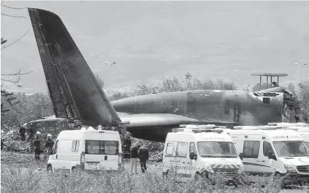  ??  ?? Firefighte­rs and civil security officers work at the scene of Wednesday’s plane crash near a military base in Boufarik, Algeria.