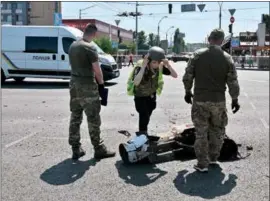  ?? (AFP) ?? Police experts examine fragments of a missile after Russia fired a barrage of missiles for the second time in 24 hours, in an unusual daytime attack targetting the Ukrainian capital following overnight strikes, in Kiev on Monday.