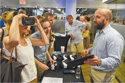  ?? STAFF PHOTO BY ANGELA LEWIS FOSTER ?? Reed Hayes, right, with Rendever, talks with Amy Sturgill, Ellen Cummings and Evan Thibaud, from left, Wednesday at Gigtank365’s Pitch Night at the Edney Innovation Center.